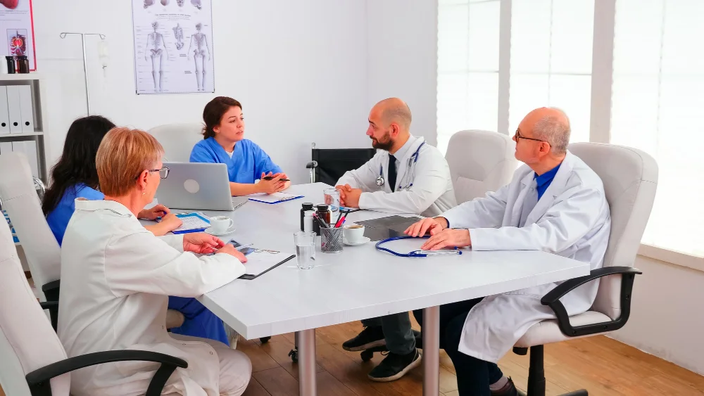 Equipo médico coordinando la atención de pacientes en una reunión