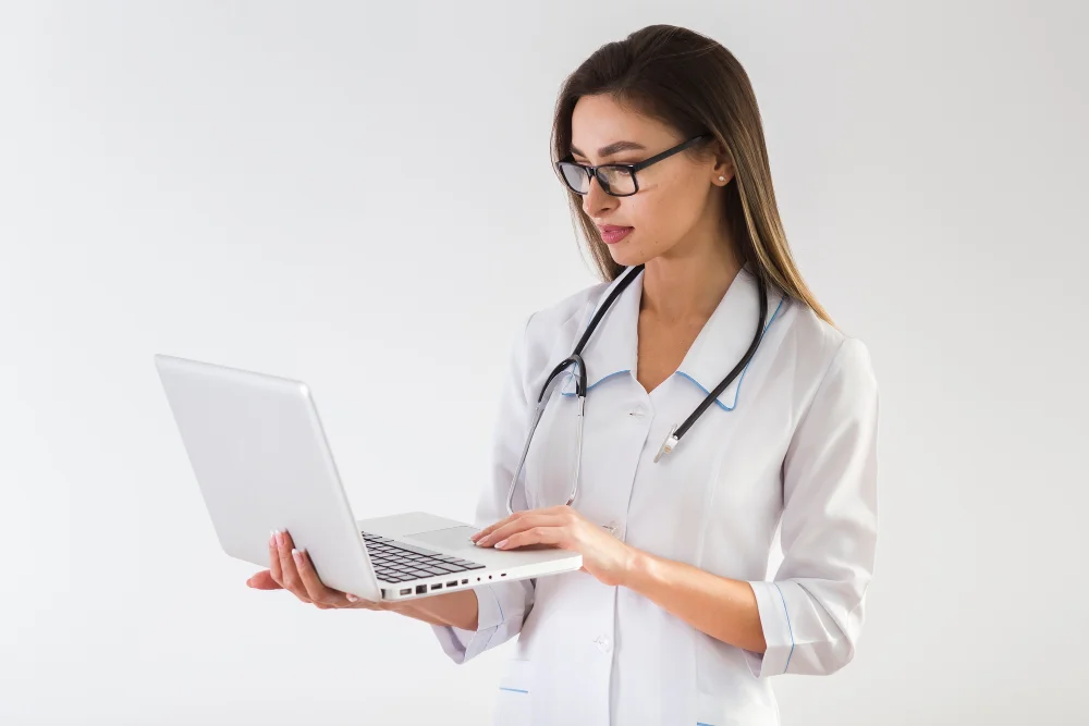 Médica consultando un sistema de gestión de pacientes en el ordenador